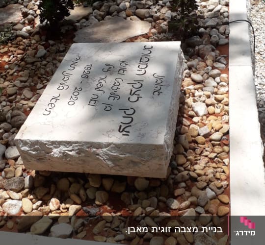מצבות עם כיתוב בעברית ואבנים קטנות מסביב